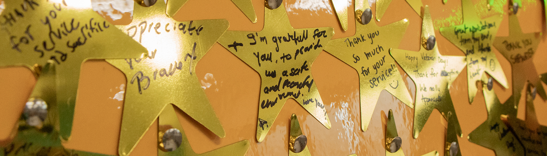 Closeup of shiny gold stars with messages like thank you for your service